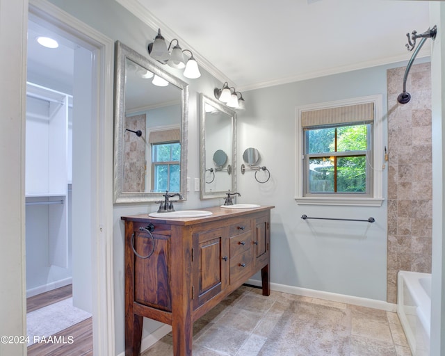 bathroom with crown molding, baseboards, and a sink