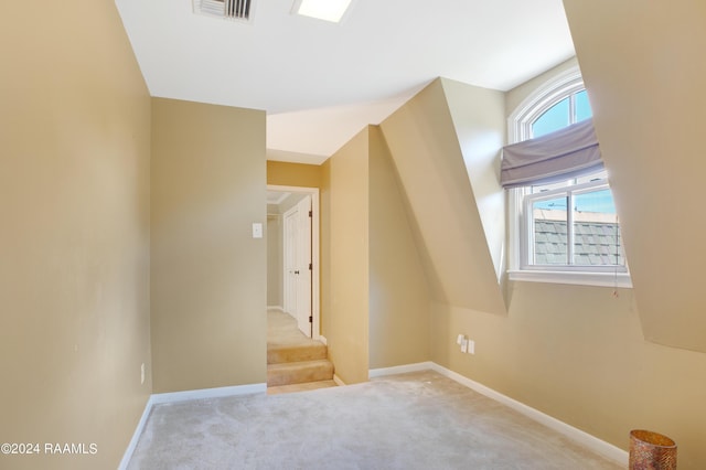 additional living space with carpet floors, visible vents, and baseboards