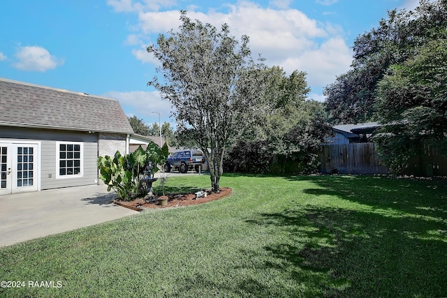 view of yard featuring french doors, fence, and a patio