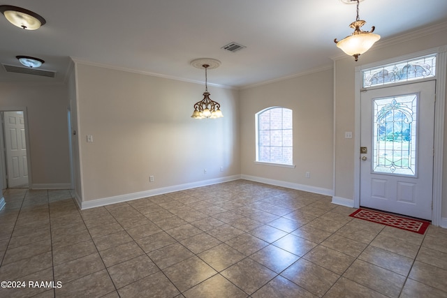 tiled foyer with an inviting chandelier and crown molding