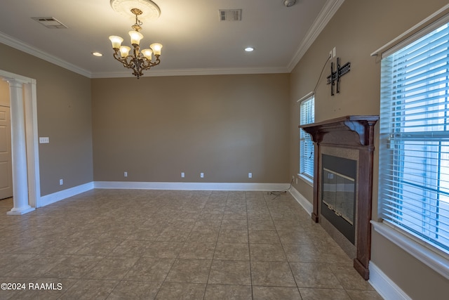 unfurnished living room with ornamental molding, tile patterned floors, a chandelier, and ornate columns