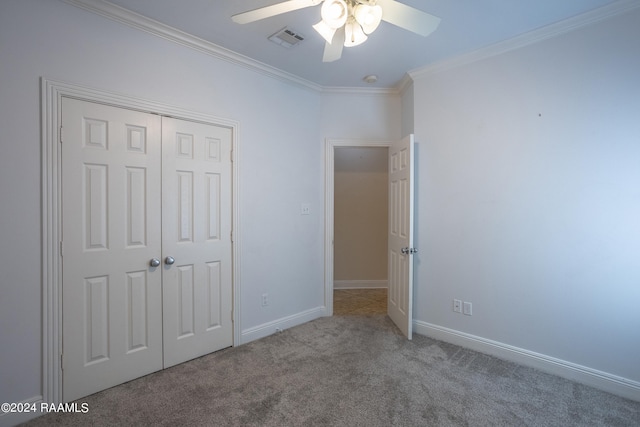 unfurnished bedroom featuring crown molding, carpet flooring, ceiling fan, and a closet