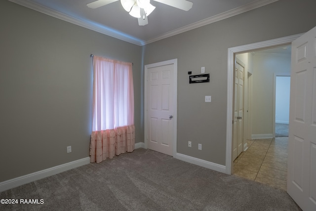 unfurnished bedroom with light carpet, ornamental molding, and ceiling fan