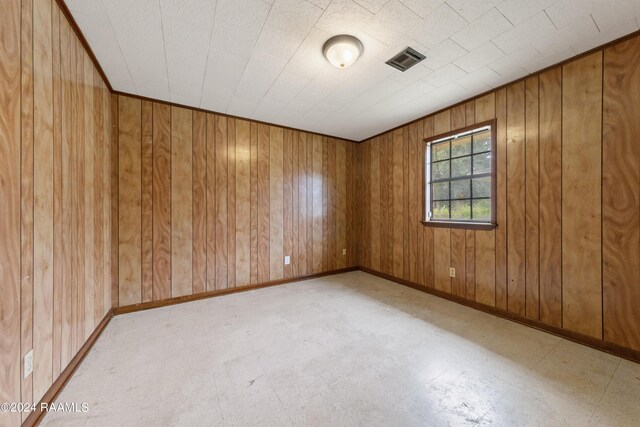 tiled spare room with wood walls