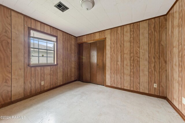 tiled spare room with wood walls