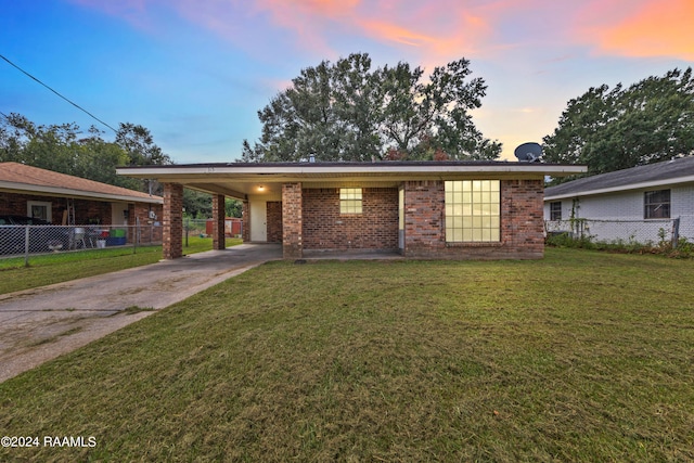 ranch-style home with a lawn and a carport