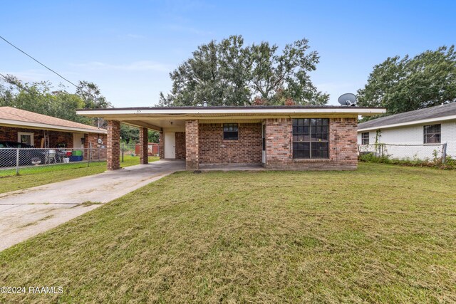 ranch-style home featuring a carport and a front yard