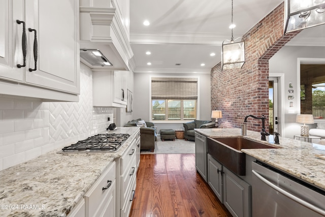 kitchen with dark hardwood / wood-style flooring, custom range hood, appliances with stainless steel finishes, sink, and white cabinets