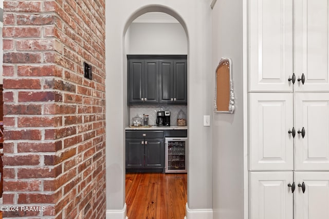 bar with white cabinetry, beverage cooler, hardwood / wood-style flooring, and tasteful backsplash