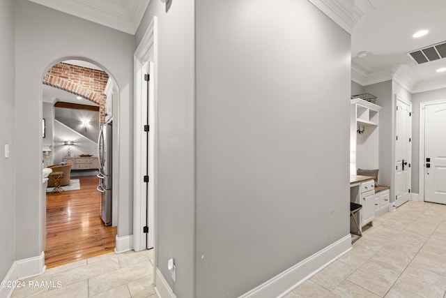 corridor featuring crown molding and light tile patterned flooring