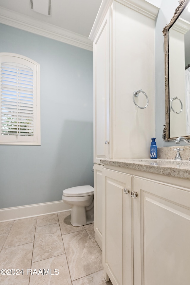 bathroom with tile patterned flooring, vanity, toilet, and ornamental molding