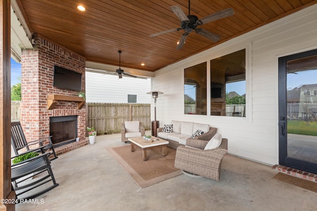 view of patio / terrace featuring ceiling fan and an outdoor living space with a fireplace