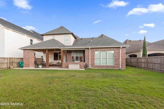 back of house featuring a lawn and a patio