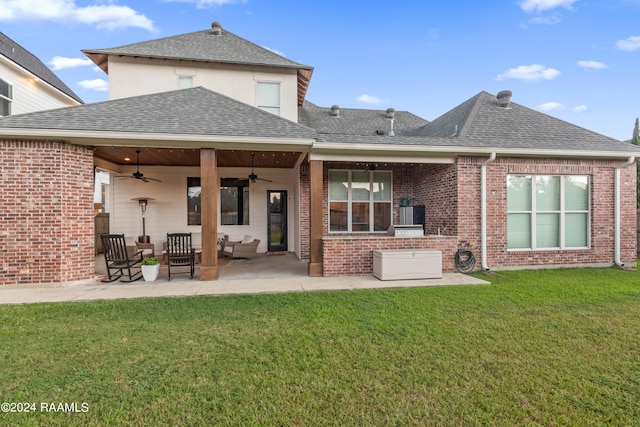 back of property with a lawn, ceiling fan, and a patio area