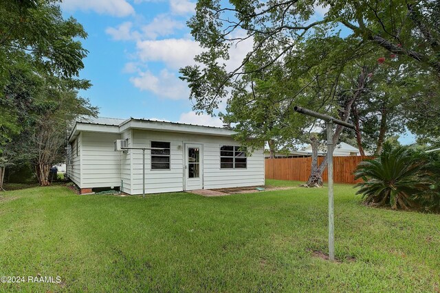 rear view of property featuring a lawn