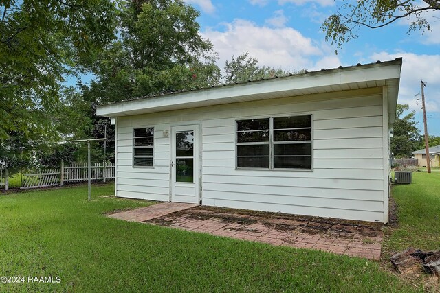 view of outbuilding featuring a yard and central AC