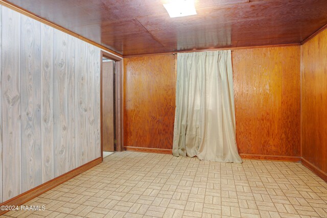 spare room with wood walls