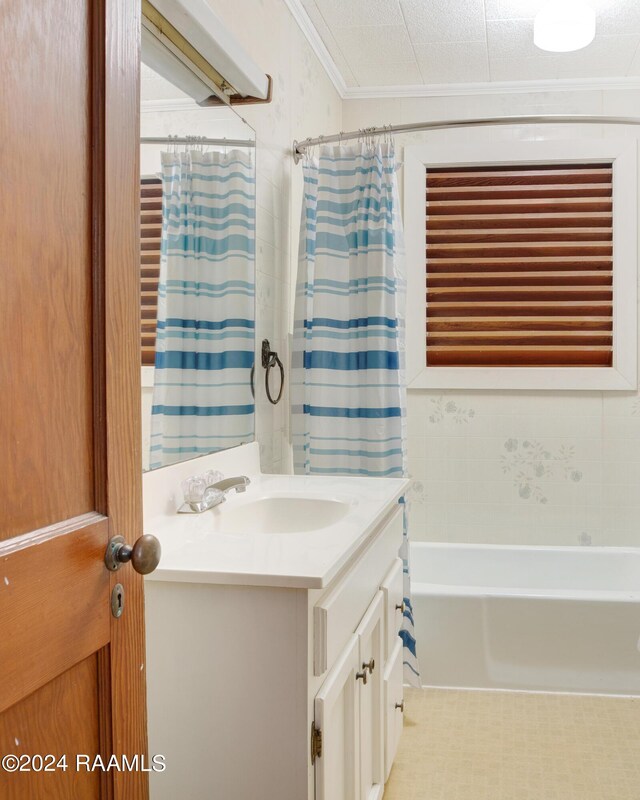 bathroom with shower / bath combo with shower curtain, ornamental molding, and vanity