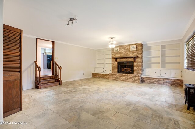 unfurnished living room featuring ornamental molding, a brick fireplace, and built in shelves