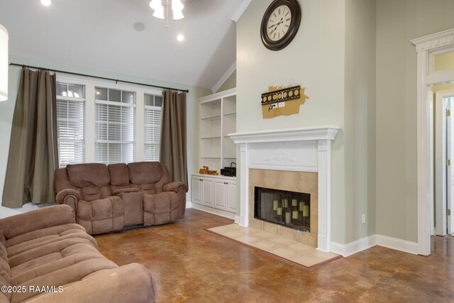 living room with a tile fireplace, vaulted ceiling, concrete floors, and built in shelves