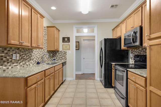 kitchen with sink, light tile patterned floors, stainless steel appliances, light stone counters, and ornamental molding