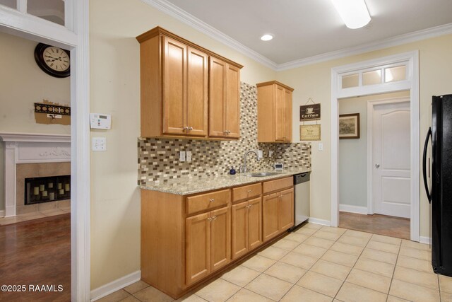 kitchen with sink, crown molding, black refrigerator, stainless steel dishwasher, and backsplash