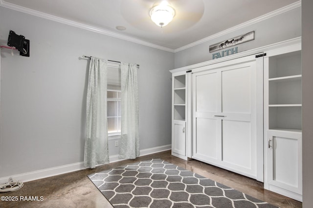 unfurnished bedroom with ornamental molding, a barn door, and a closet