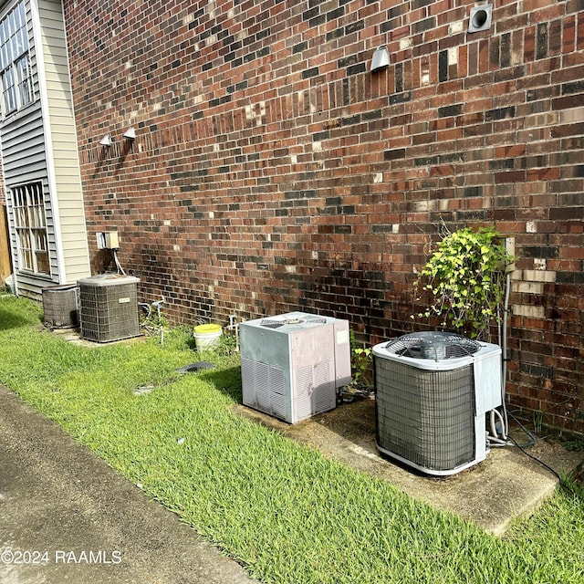 details featuring cooling unit and brick siding