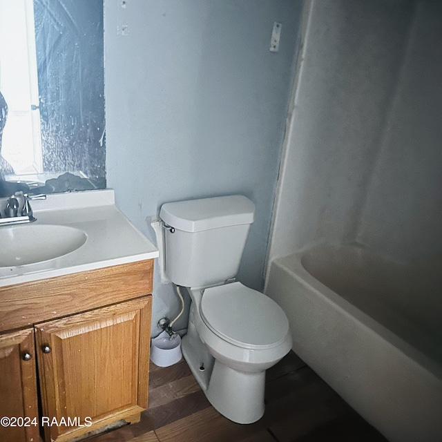 bathroom featuring toilet, a washtub, wood finished floors, a shower, and vanity