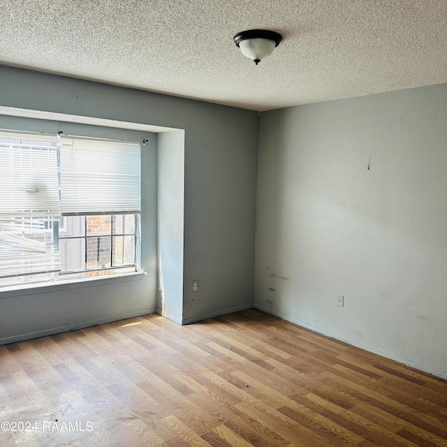 spare room with wood finished floors and a textured ceiling