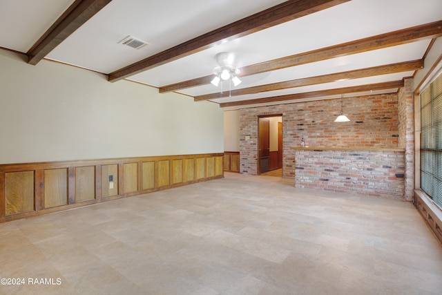 empty room with brick wall, ceiling fan, and beamed ceiling