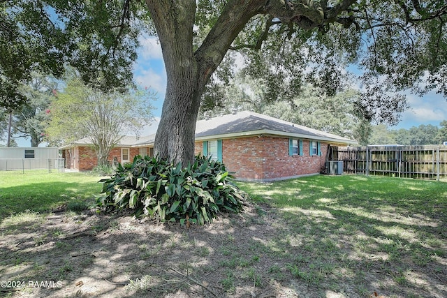 view of yard with fence and central AC unit
