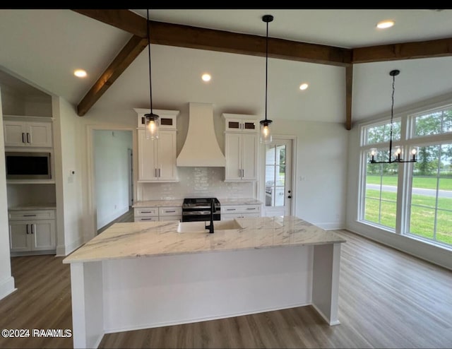 kitchen featuring custom exhaust hood, vaulted ceiling with beams, dark wood-type flooring, white cabinets, and a large island