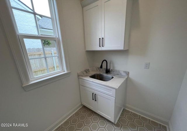 laundry area with a sink and baseboards