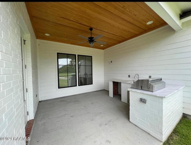 view of patio with exterior kitchen and a ceiling fan