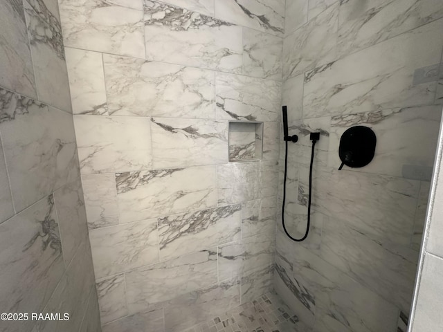 bathroom featuring a marble finish shower