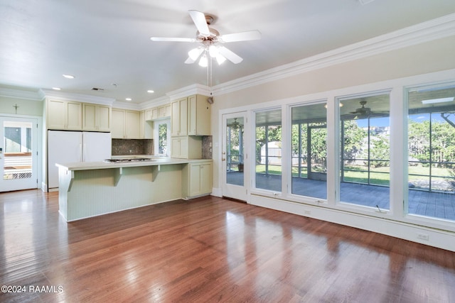 kitchen featuring white fridge, a healthy amount of sunlight, light hardwood / wood-style floors, and kitchen peninsula