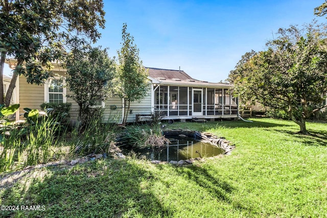 back of house with a sunroom and a lawn