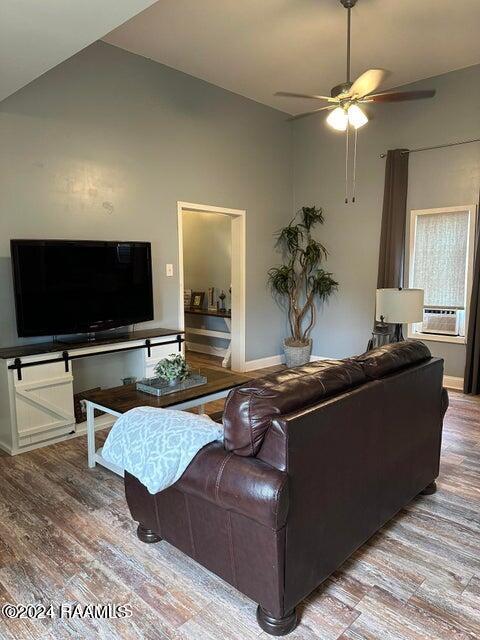 living room featuring lofted ceiling, ceiling fan, cooling unit, and wood-type flooring