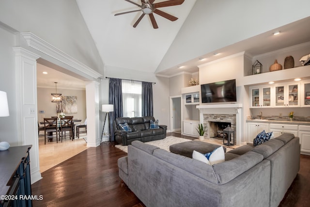 living room featuring a fireplace, crown molding, dark hardwood / wood-style flooring, ceiling fan, and high vaulted ceiling