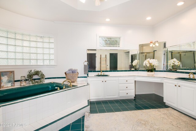 bathroom with crown molding, tiled bath, vanity, and tile patterned floors