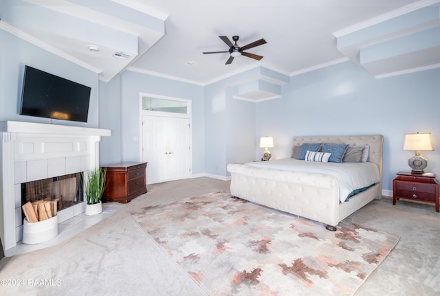 carpeted bedroom with ceiling fan, a fireplace, and ornamental molding