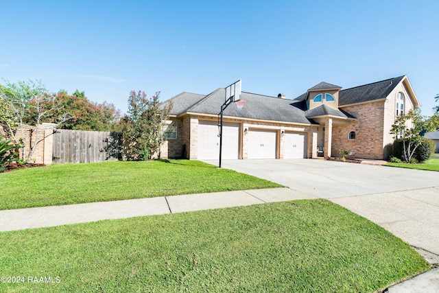 traditional-style house featuring a garage, concrete driveway, brick siding, and a front lawn