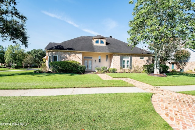 view of front of home with french doors, a front lawn, and brick siding