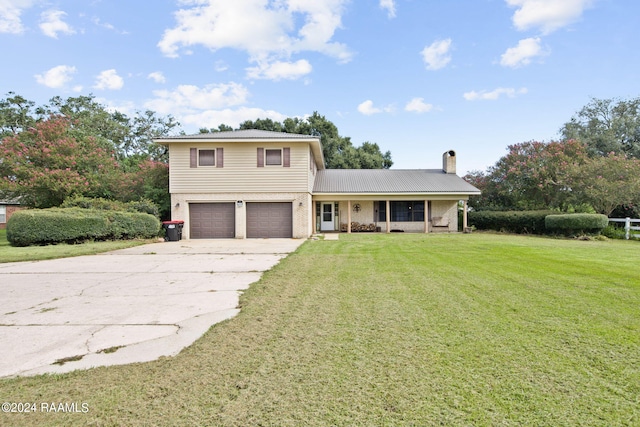 view of property with covered porch, a garage, and a front lawn