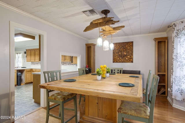 dining room featuring crown molding, a notable chandelier, and light wood-type flooring