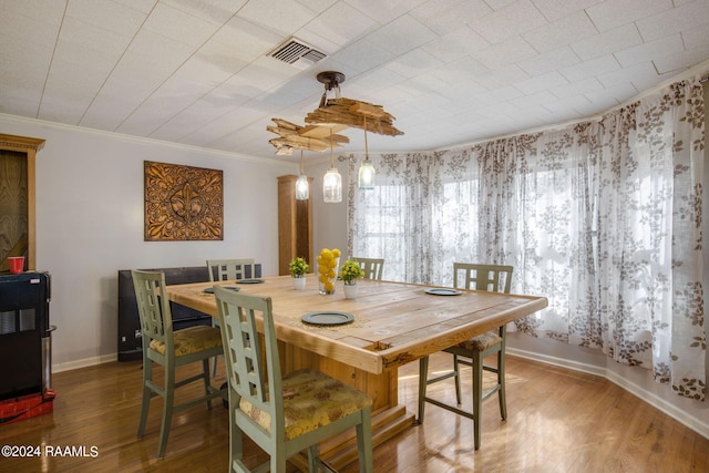 dining space featuring hardwood / wood-style floors and crown molding