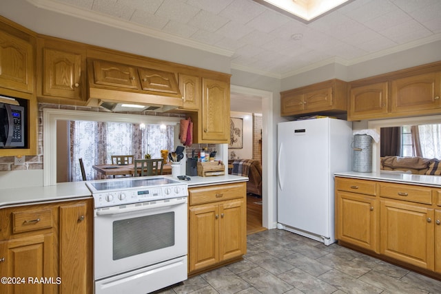 kitchen with ornamental molding and white appliances