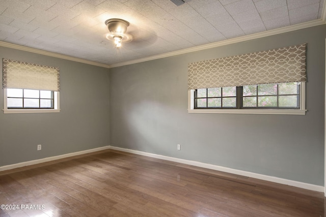 empty room featuring crown molding, wood-type flooring, and plenty of natural light