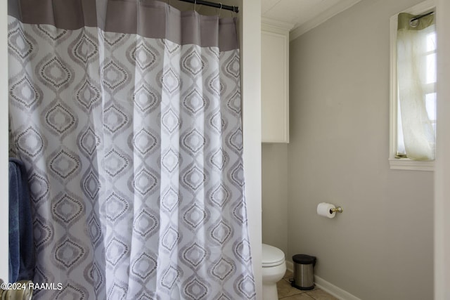 bathroom with walk in shower, crown molding, toilet, and tile patterned flooring